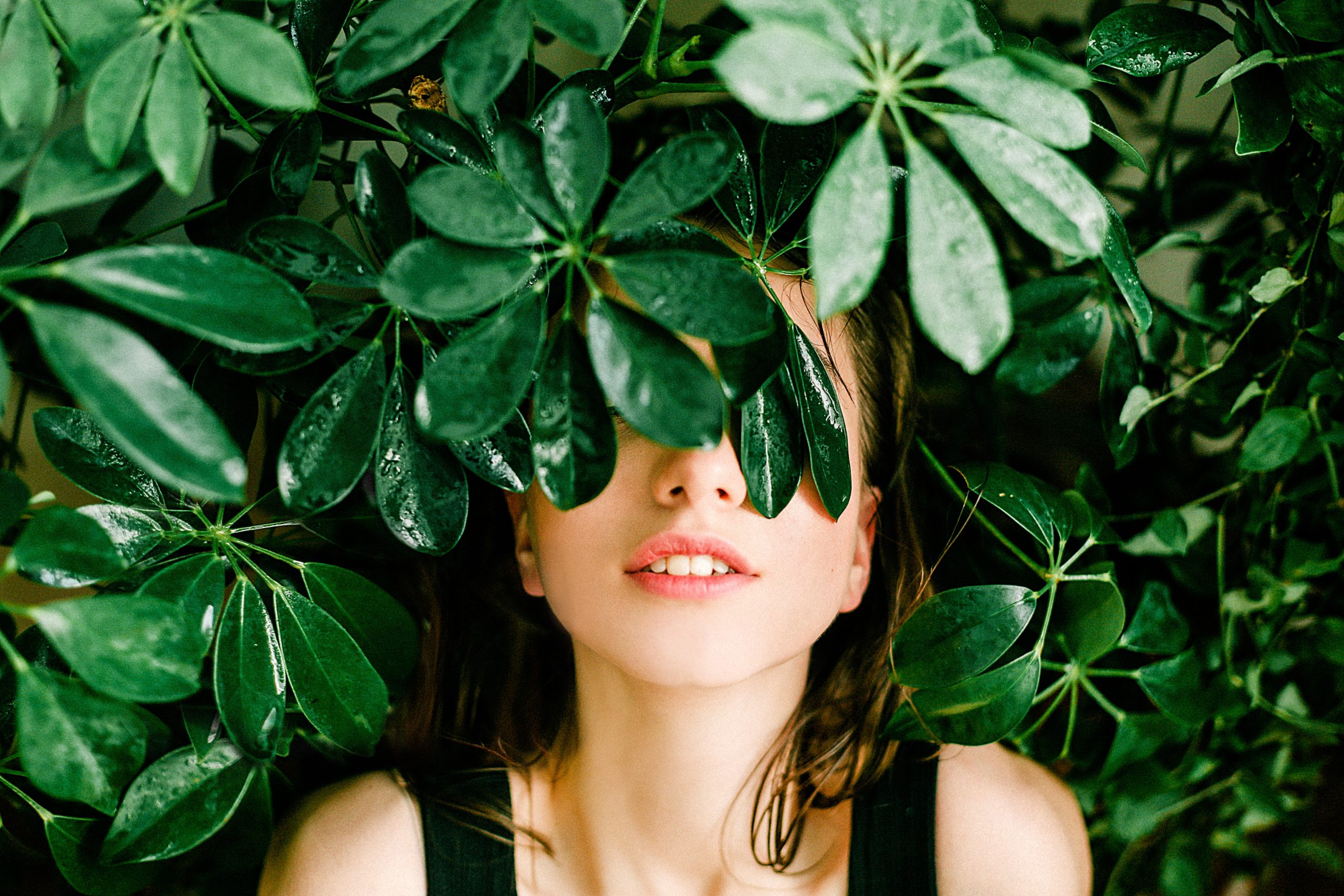 Woman in Black Top Beside Green Leafed Plant